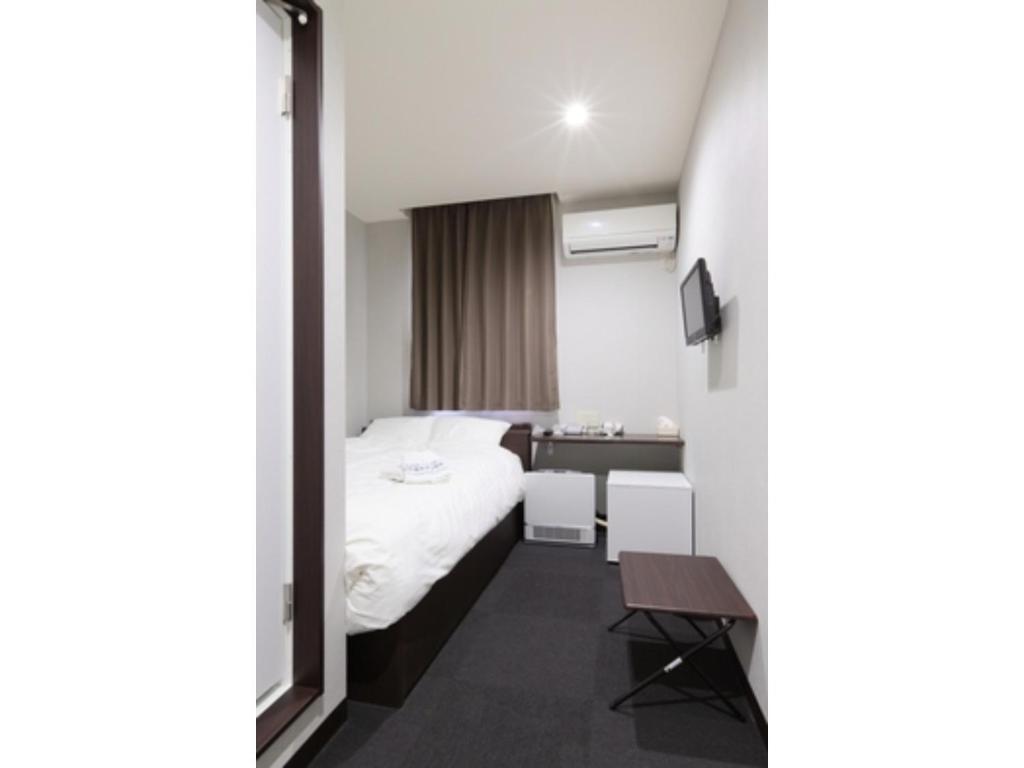 草津的住宿－Kusatsu Onsen 326 Yamanoyu Hotel - Vacation STAY 10349v，酒店客房配有一张床铺和一张桌子。
