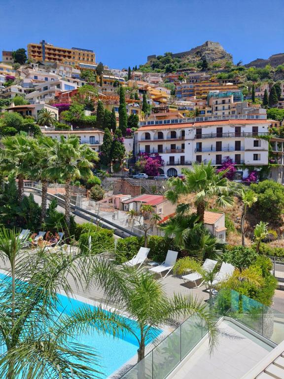 a view of a resort with a pool and palm trees at MINERVA LUXURY TOWN CENTER , POOL AND PARKING in Taormina