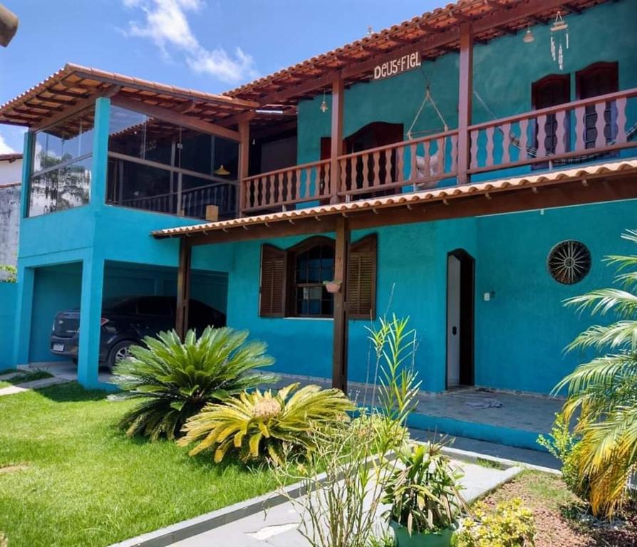 a blue house with a balcony at Casa em Miguel Pereira in Miguel Pereira
