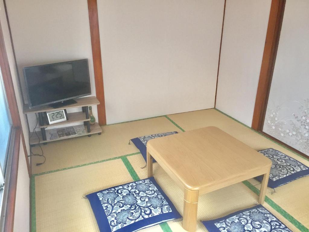 um pequeno quarto com uma mesa e uma televisão em D-pdal Inn - Vacation STAY 38493v em Tóquio