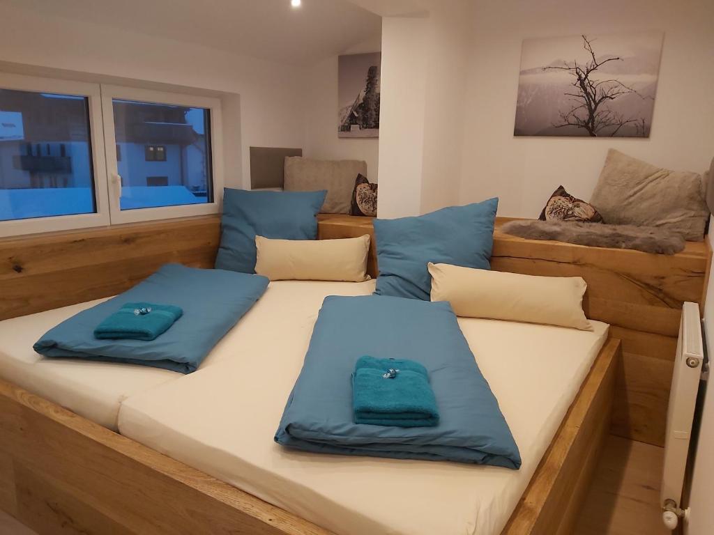 dos almohadas azules sentadas en una cama en una habitación en Penthouse-Feeling MaBeA, en Innsbruck