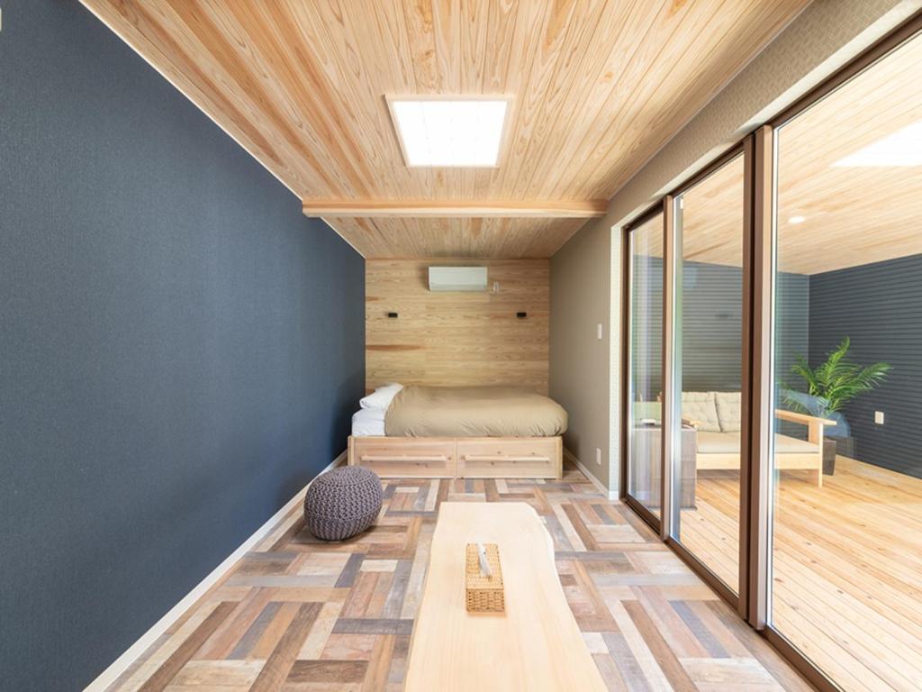 een slaapkamer met een bed en een houten plafond bij STELLA SPORTS - Vacation STAY 46140v in Nishimera