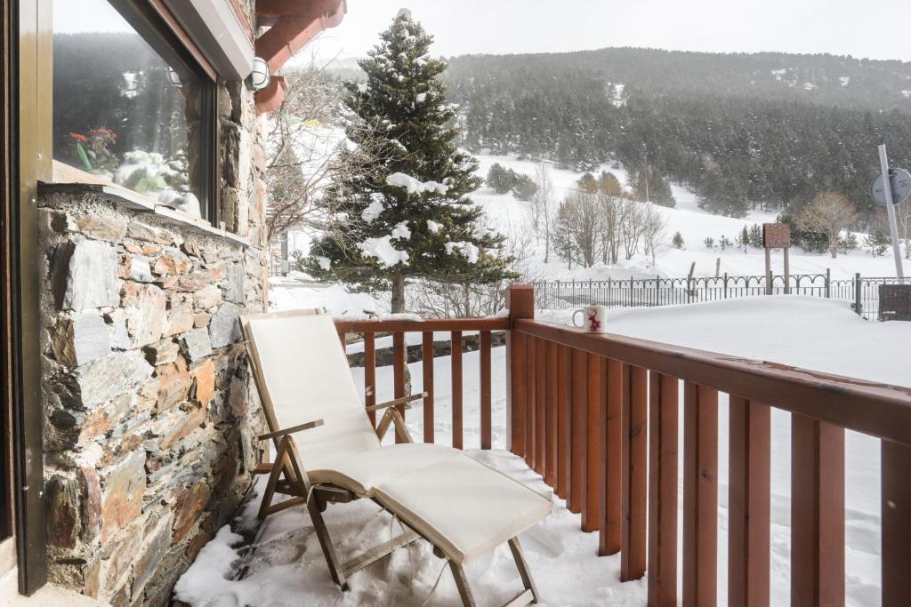 ein weißer Stuhl auf einem Balkon im Schnee in der Unterkunft Appartement Chalet Vall d Incles Résidence Deu Sol in Canillo