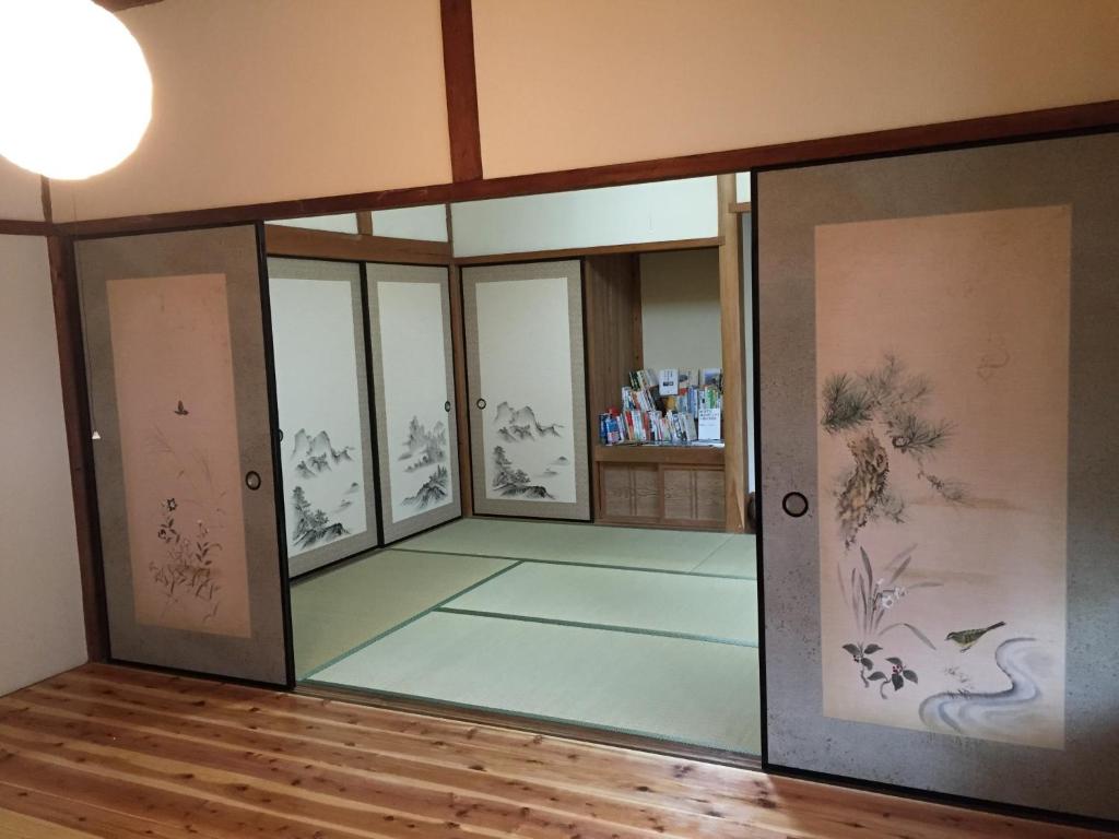 um quarto com portas de vidro e pinturas nas paredes em Satoyama Guest House Couture - Vacation STAY 43859v em Ayabe