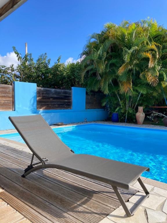 a chair sitting next to a swimming pool at Villa La Roserie in Ducos