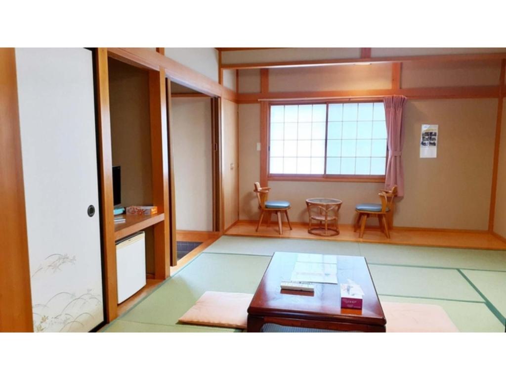 a living room with a table and a window at Sudomari no Yado Sunmore - Vacation STAY 46734v in Nikko
