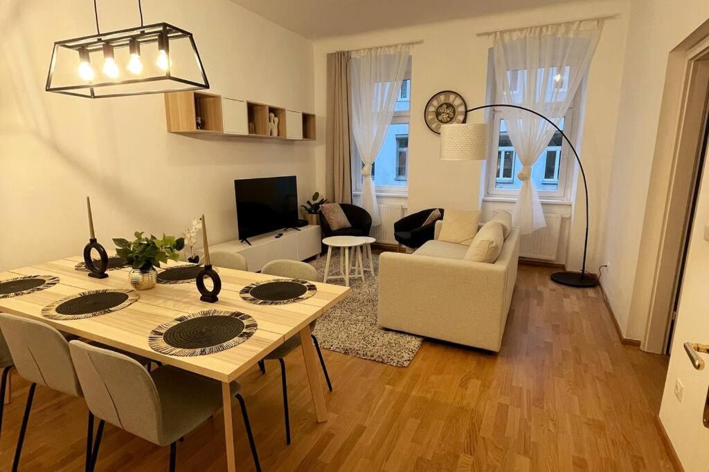 uma cozinha e sala de estar com mesa e cadeiras em OrestaLiving - BrigittineurLände em Viena