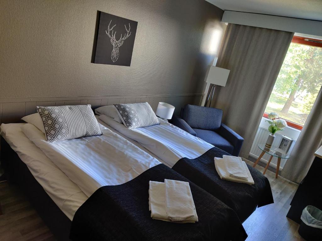 1 dormitorio con 1 cama grande y 1 silla azul en Ellivuori. Ellin Pooli 4, en Sastamala