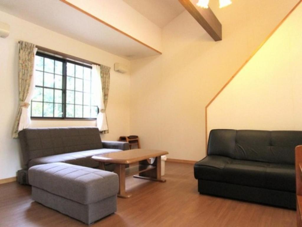 uma sala de estar com um sofá e uma mesa em Sudomari no Yado Sunmore - Vacation STAY 46748v em Nikko