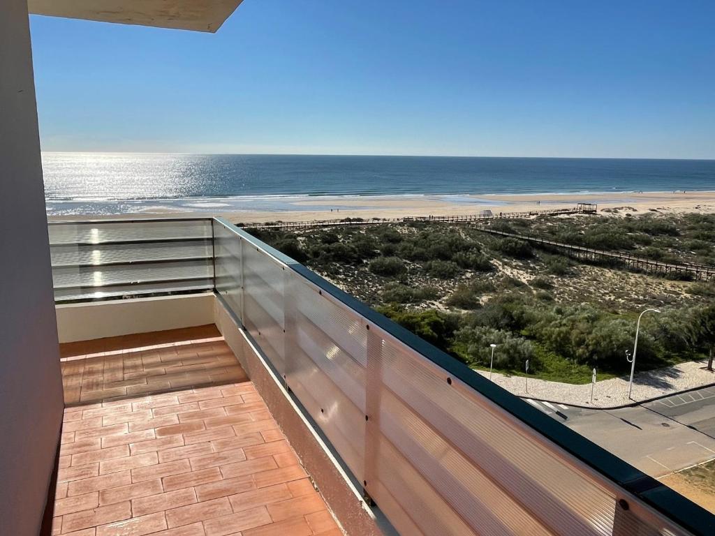 uma varanda com vista para a praia em Over the Beach em Monte Gordo