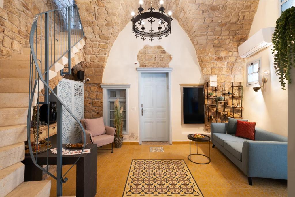 a living room with a blue couch and a staircase at Villa Sera in Acre