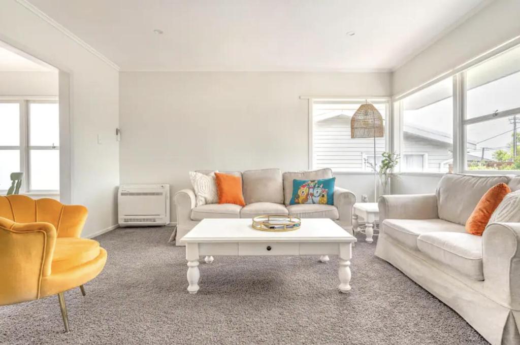 uma sala de estar com dois sofás e uma mesa de centro em Bright & Central Home em Auckland