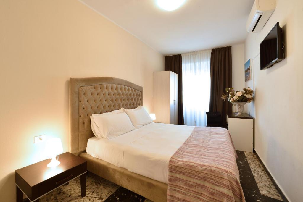 a hotel room with a large bed and a table at Hotel Ristorante La Marina Mhotelsgroup in San Bartolomeo al Mare