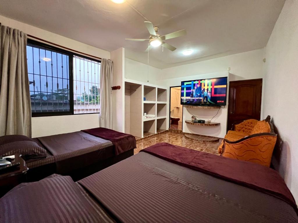a living room with two beds and a flat screen tv at Family queen size in Minatitlán