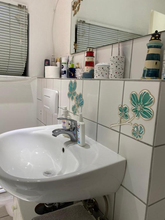 a bathroom with a white sink and a mirror at Helles Appartment in Bremen
