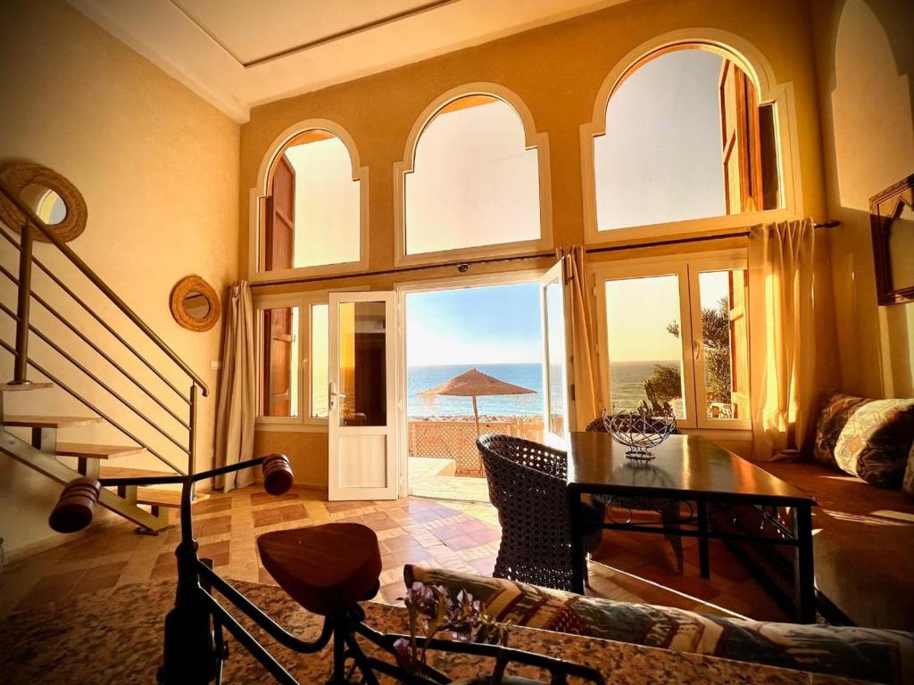 a living room with a large window with a view of the ocean at Dar diafa samira in Mirleft