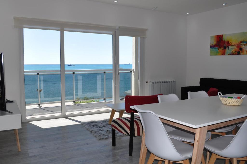 a dining room with a table and a view of the ocean at Edificio Frente al Mar - Amplios departamentos in Caleta Olivia