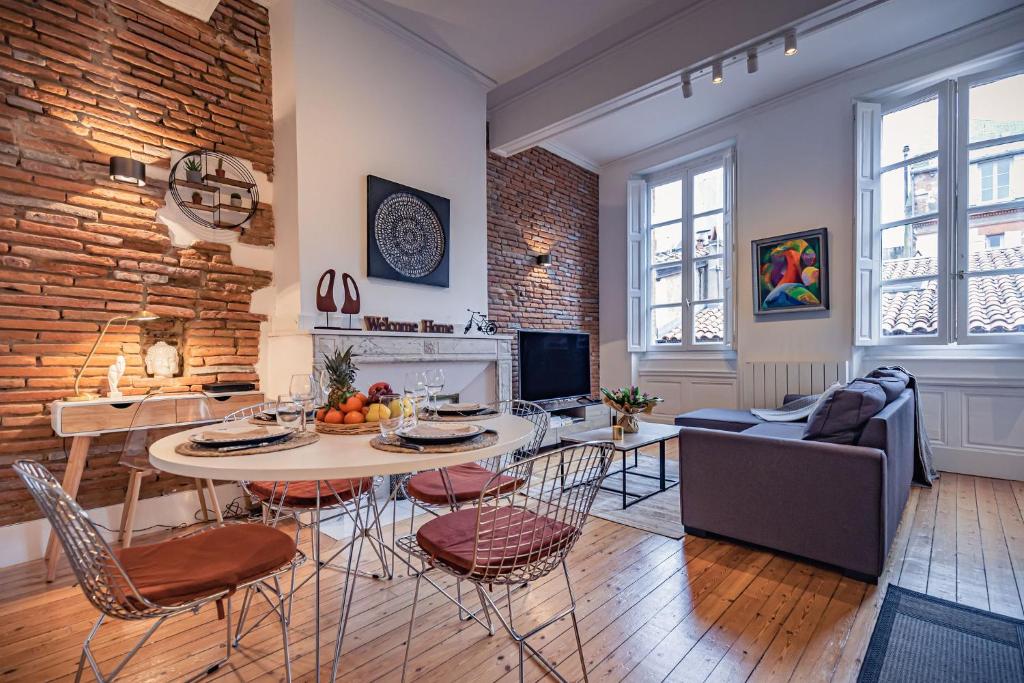 une cuisine et un salon avec une table et des chaises dans l'établissement Le Vélane 45m2 - Toulouse Centre - Proche Capitole, à Toulouse