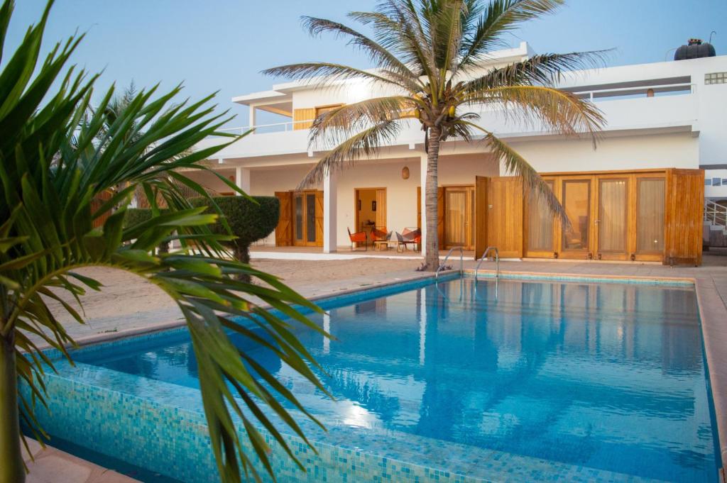 - une piscine avec un palmier en face d'une maison dans l'établissement Sur la Plage Yenne, à Yenne-Todé
