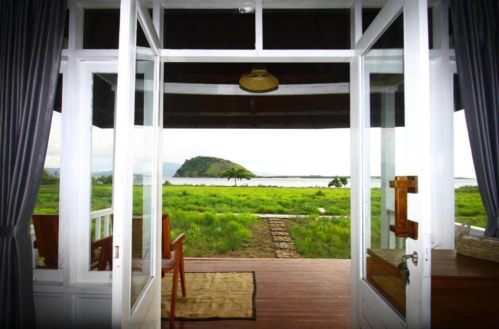 an open door with a view of a field at PASERANG PARIRI PARADISE in Labuberu