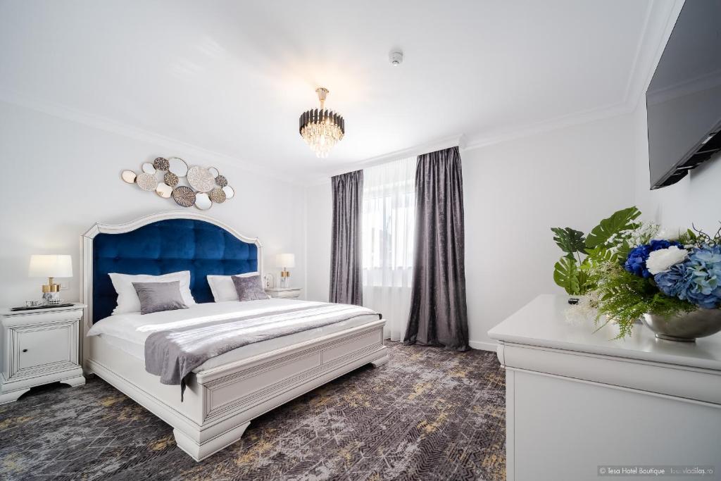 特爾古尼亞姆茨的住宿－Tesa Boutique Hotel，一间卧室配有一张大床和蓝色床头板