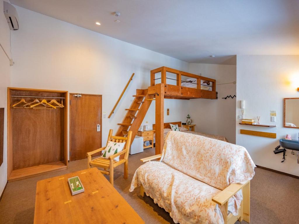 uma sala de estar com uma cama alta e um sofá em Zao Onsen Lodge Sukore - Vacation STAY 55487v em Yamagata