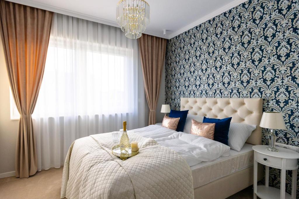 Un dormitorio con una cama grande y una lámpara de araña. en ZB Apartment Luxor Bobrowniki Rogożnik Pyrzowice, 