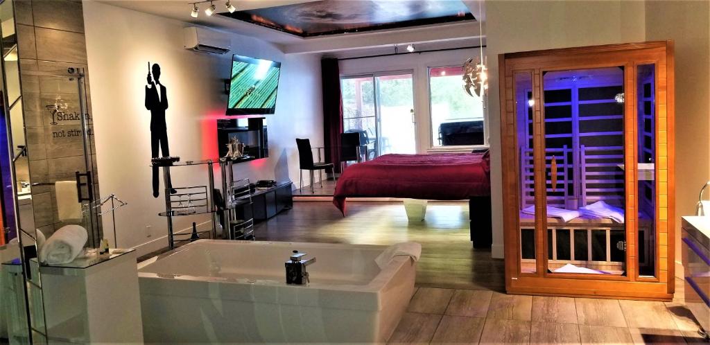 a large bathroom with a tub and a bedroom at Auberge Aux Nuits de Rêve in Sainte-Agathe-des-Monts