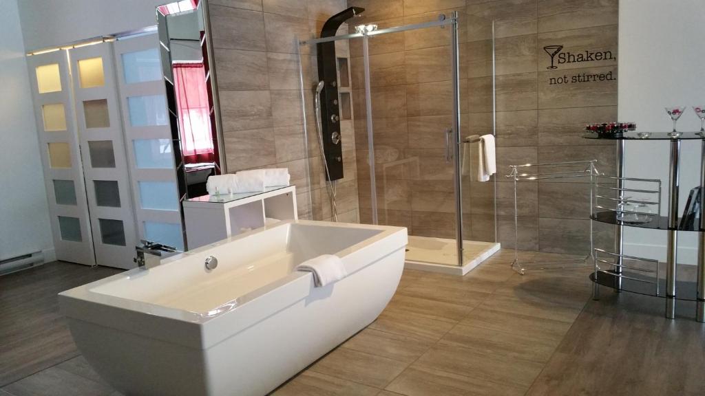 a bathroom with a bath tub and a shower at Auberge Aux Nuits de Rêve in Sainte-Agathe-des-Monts
