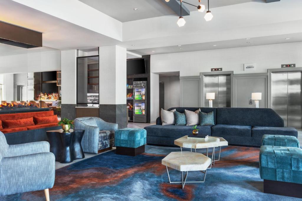 una sala de estar con sofás y sillas azules en Delta Hotels by Marriott Midwest City at the Reed Conference Center en Del City