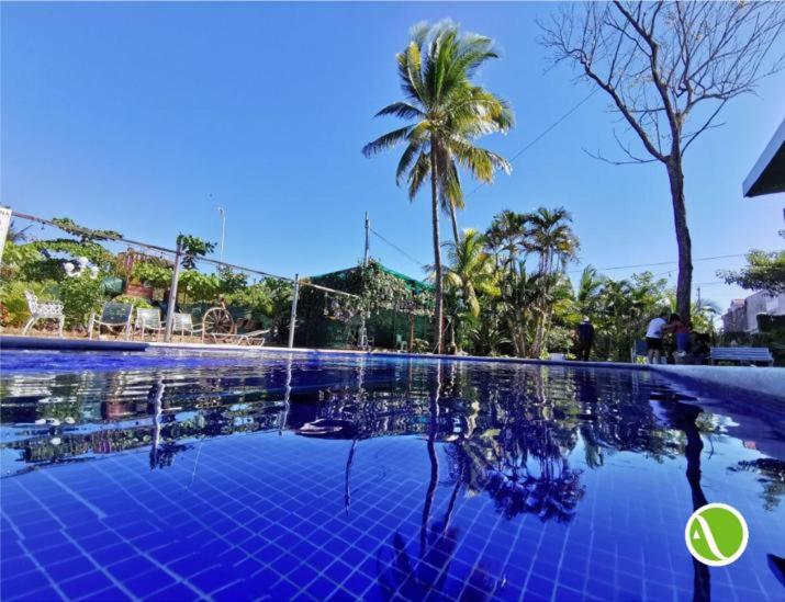 una piscina con palmeras y un azul en Argueta Hotel, en San Luis