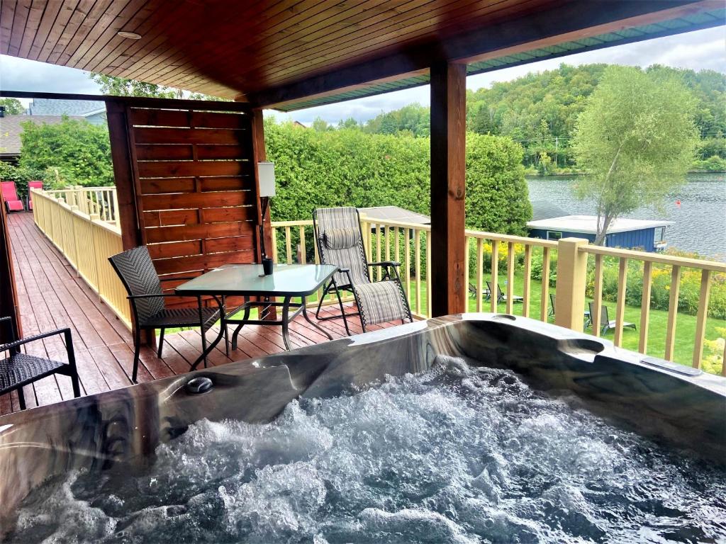 a hot tub on the deck of a house at Auberge Aux Nuits de Rêve in Sainte-Agathe-des-Monts