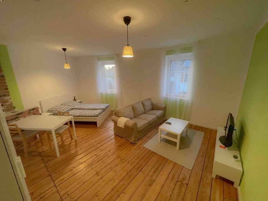 uma sala de estar com um sofá e uma mesa em Das Haus am Bach - Schöne große moderne Wohnung mit Terrasse em Osthofen