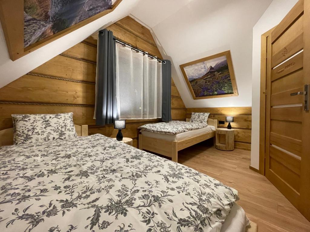 Schlafzimmer mit einem Bett und einem Fenster in der Unterkunft Domki przy skwerku in Zakopane