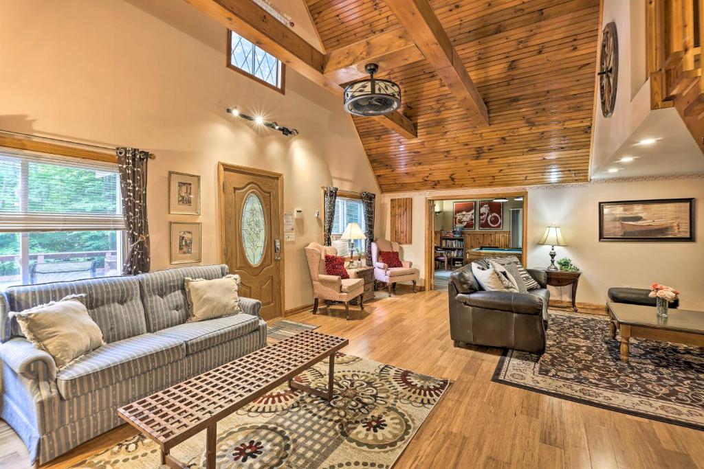 a living room with a couch and a table at Arrowhead Lake Home with Game Room and Beach Access! in Pocono Lake