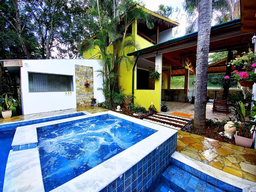 a swimming pool in front of a house at Pousada Della Vegas in Serra Negra