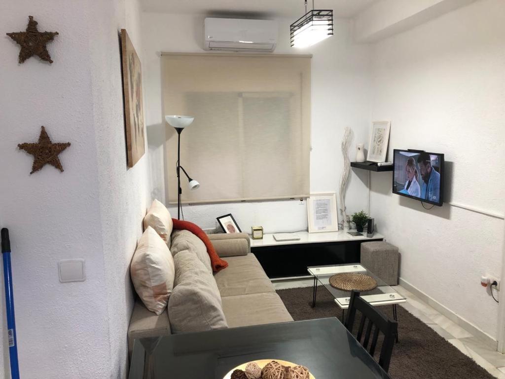 ein Wohnzimmer mit einem Sofa und einem Tisch in der Unterkunft Tablada Los Remedios in Sevilla