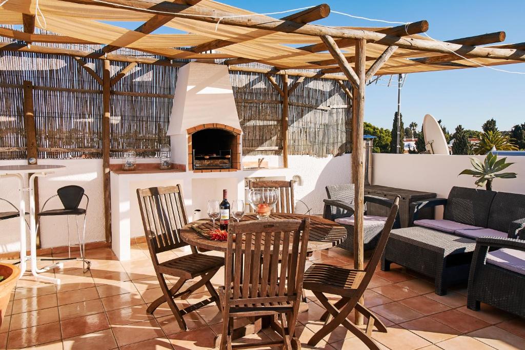 a patio with a table and chairs and a fireplace at Apartment Kornelius in Carvoeiro