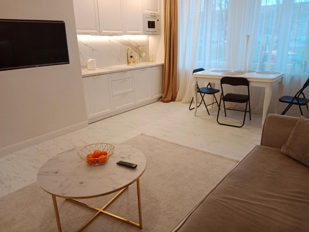 een woonkamer met een bank en een tafel bij Apartament Glamour Chełm in Chełm