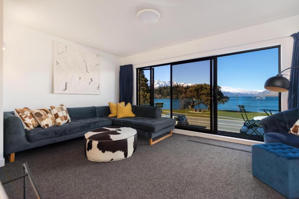 a living room with a couch and a table at TAHUNA LAKEFRONT LUXURY, Central Location in Queenstown