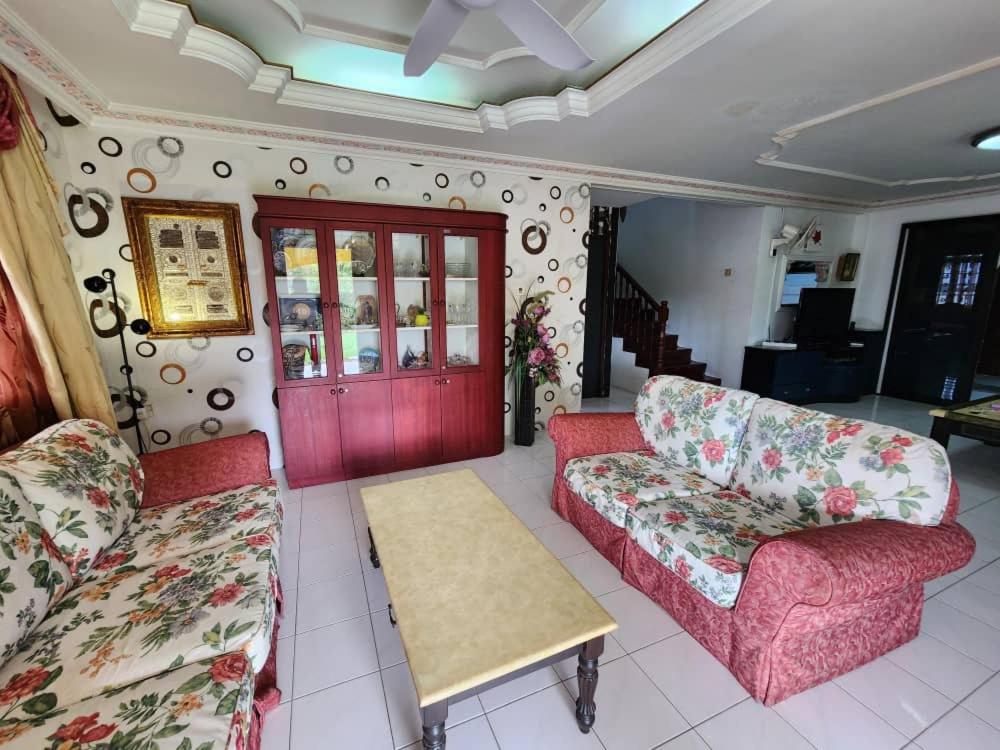 a living room with two couches and a table at Homestay Petrajaya Kuching in Kuching