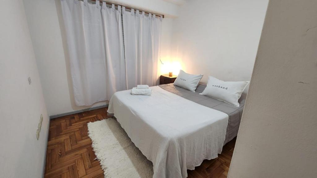 una camera da letto con un letto con lenzuola bianche e una finestra di Casa Azcuénaga - Parque - Zona comercial - Aerop 15 min a Monte Grande