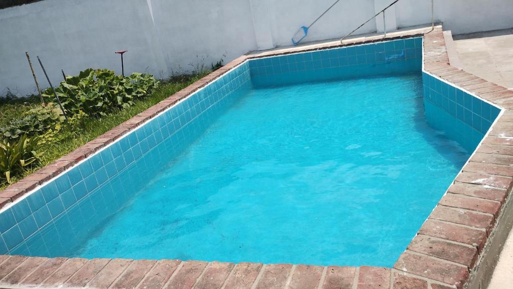 una piscina con azulejos azules en el suelo en Casa Argenta en Córdoba