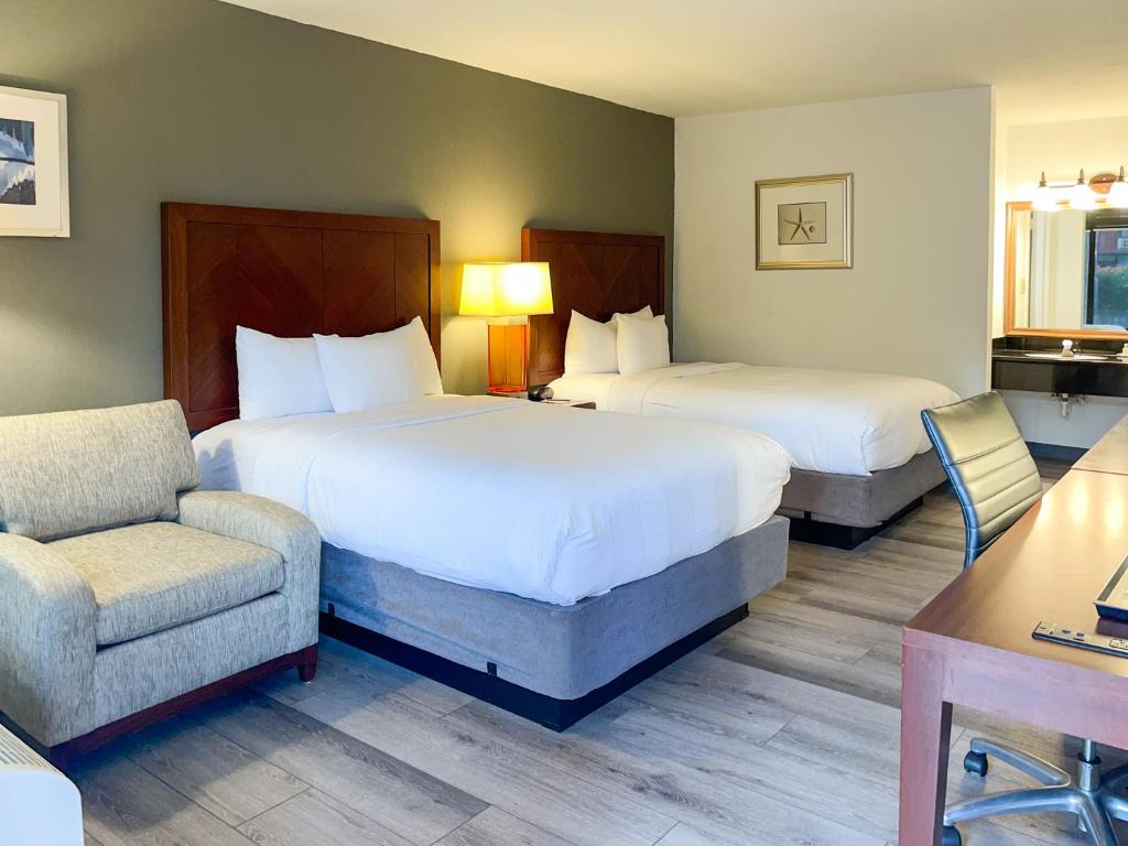 una habitación de hotel con 2 camas y una silla en GreenTree Hotel & Extended Stay I-10 FWY Houston, Channelview, Baytown, en Channelview