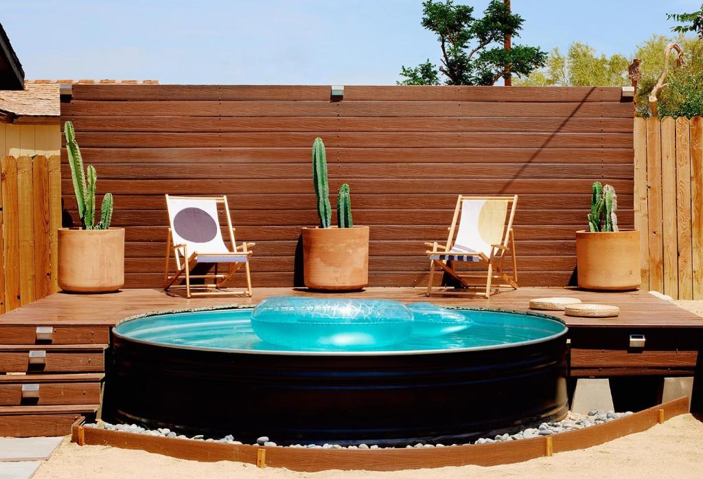 a hot tub in a patio with chairs and plants at Live Centered with Hot Tub, Fire Pit In Joshua Tree home in Joshua Tree