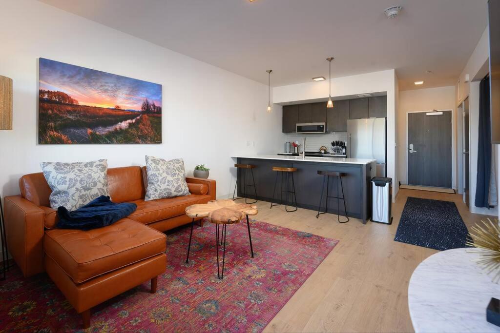 a living room with a couch and a kitchen at Stylish SoBo Condo - Steps to Main St in Bozeman