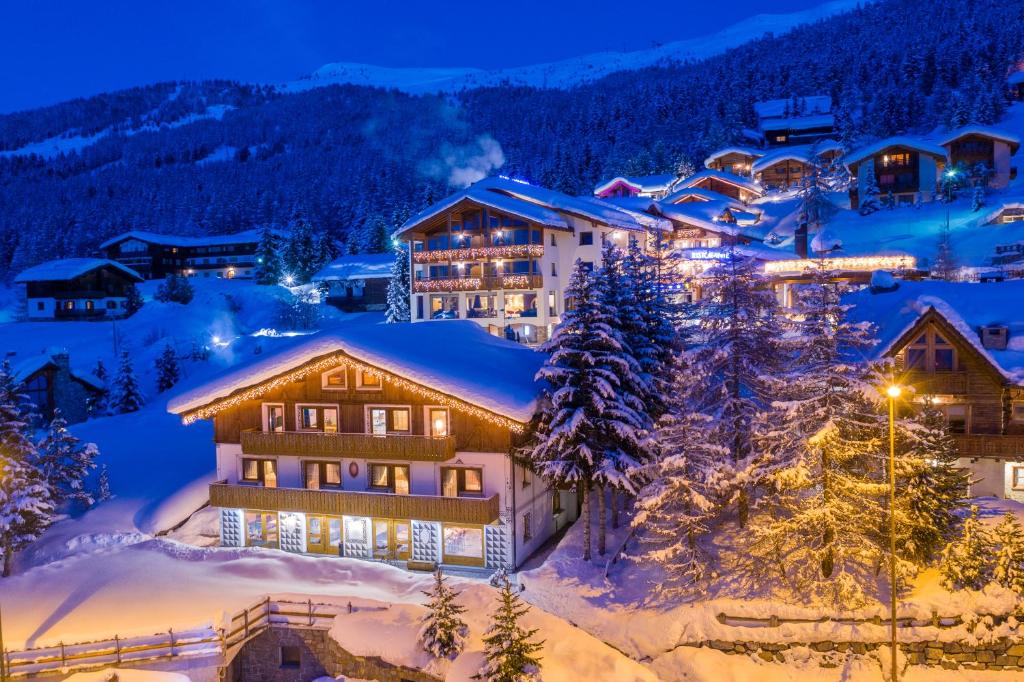 a ski lodge in the snow at night at Hotel Duc De Rohan in Livigno
