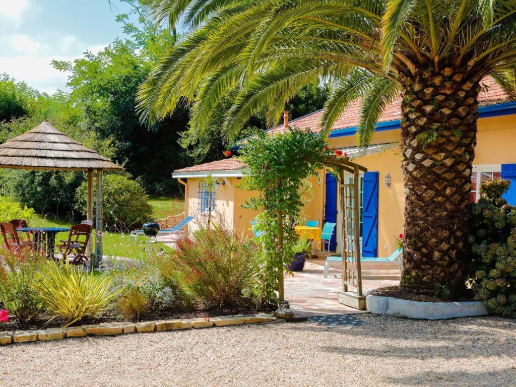 a garden with a palm tree and a house at Villa in France near Beach & Private Pool in Anglet