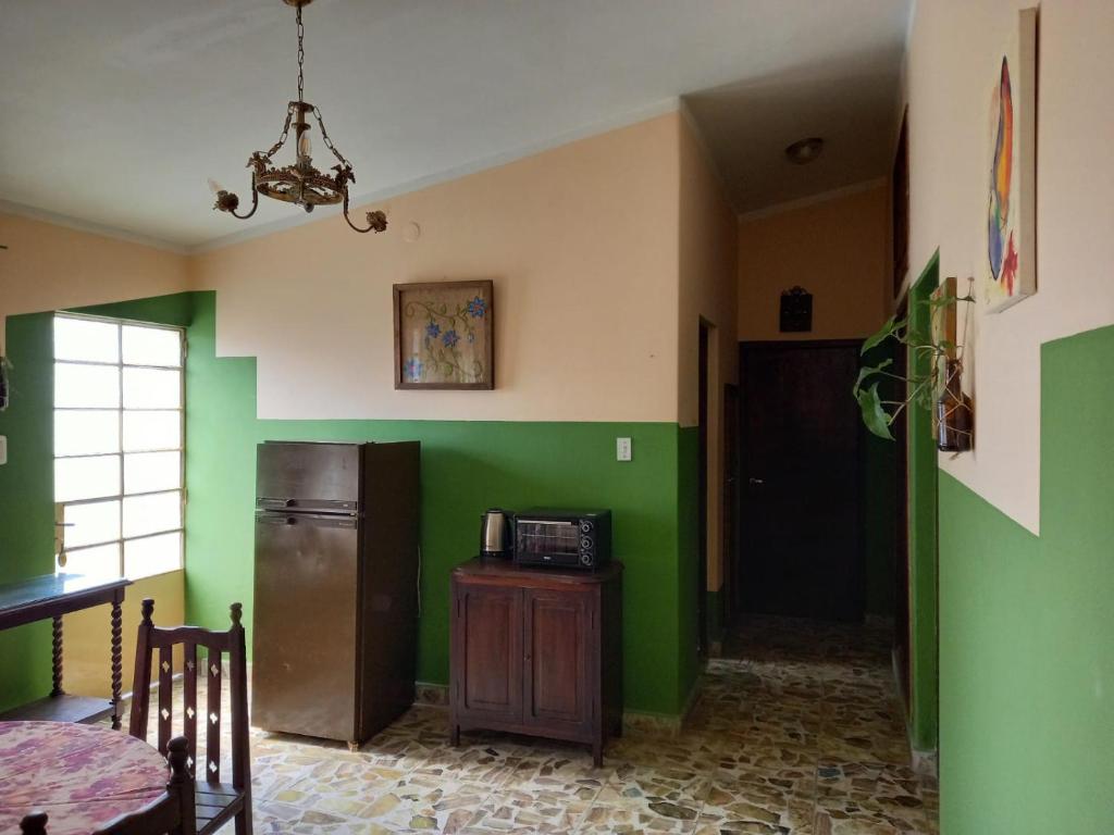 a kitchen with green walls and a refrigerator at Hospedaje in Salta