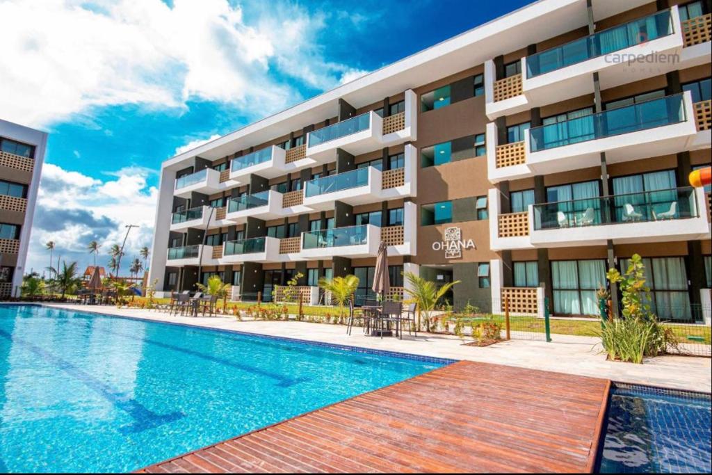 un hotel con piscina frente a un edificio en Porto Beach Resort - Mana Beach Experience, en Porto de Galinhas